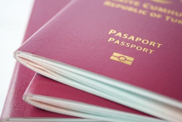 Stack Of Red Color Passport On Table Image 600x403